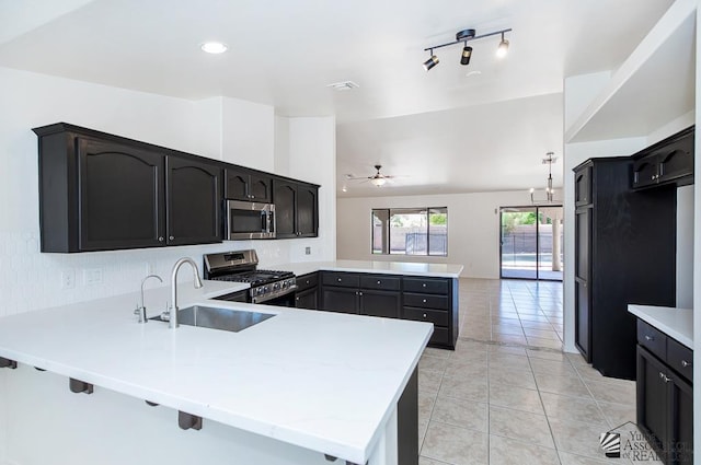 2967 S 47th Ave, Yuma, AZ 85364 - kitchen featuring appliances with stainless steel finishes, a peninsula, ceiling fan, light tile patterned floors, and backsplash