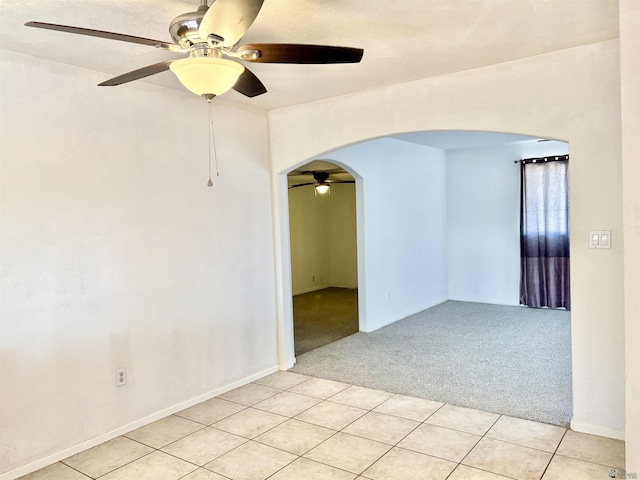 1805 S Dora Ave, Yuma, AZ 85364 - unfurnished room with arched walkways, ceiling fan, light colored carpet, and light tile patterned floors