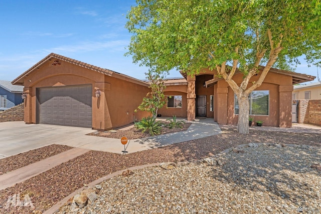 view of front of home featuring stucco siding, driveway, and a garage
