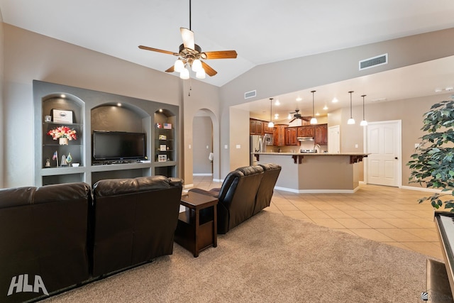 living area featuring arched walkways, ceiling fan, light tile patterned flooring, and visible vents