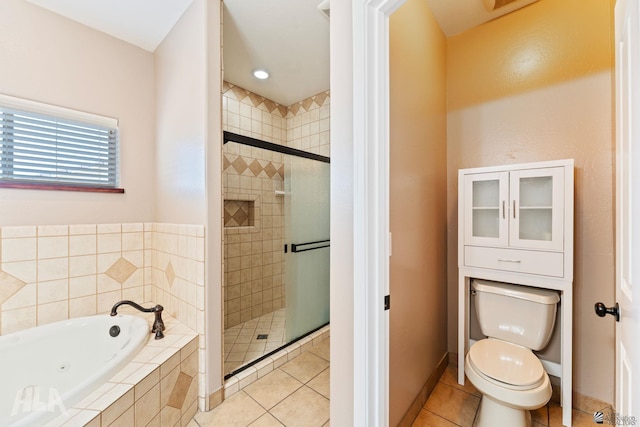 bathroom with tile patterned flooring, a whirlpool tub, a stall shower, and toilet