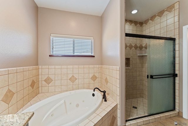 full bathroom featuring a tub with jets and a shower stall