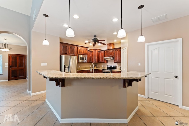 kitchen with visible vents, light tile patterned flooring, a breakfast bar, a ceiling fan, and stainless steel appliances