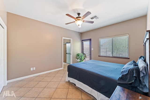 bedroom featuring connected bathroom, light tile patterned flooring, a ceiling fan, baseboards, and visible vents