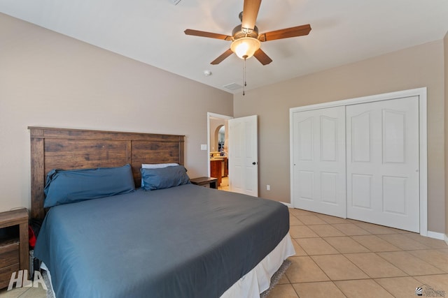 bedroom featuring baseboards, a ceiling fan, light tile patterned flooring, and a closet