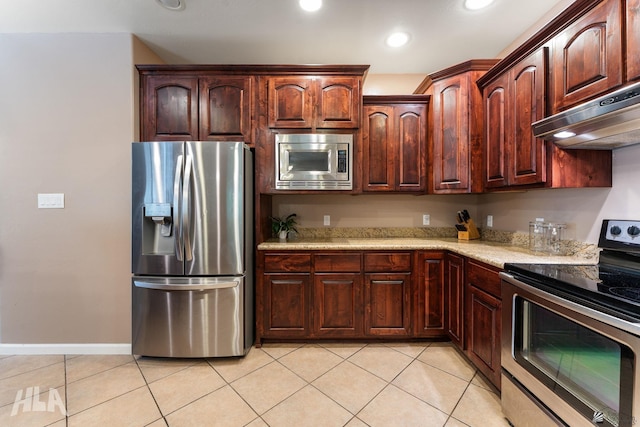 kitchen with light stone counters, under cabinet range hood, stainless steel appliances, recessed lighting, and light tile patterned flooring
