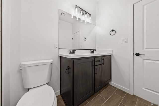 10778 E 45th Ln, Yuma, AZ 85367 - full bath with toilet, baseboards, double vanity, and wood finish floors