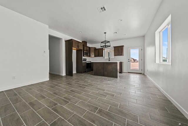 10778 E 45th Ln, Yuma, AZ 85367 - kitchen with stainless steel appliances, a sink, dark brown cabinets, light countertops, and wood tiled floors