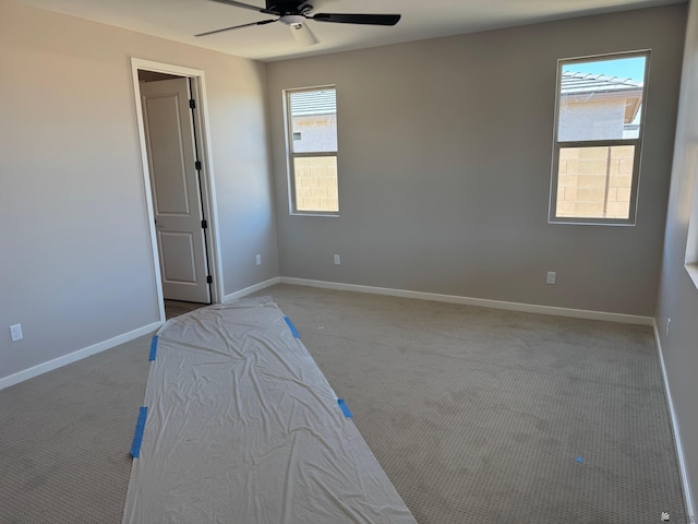 unfurnished bedroom with carpet floors, a ceiling fan, and baseboards