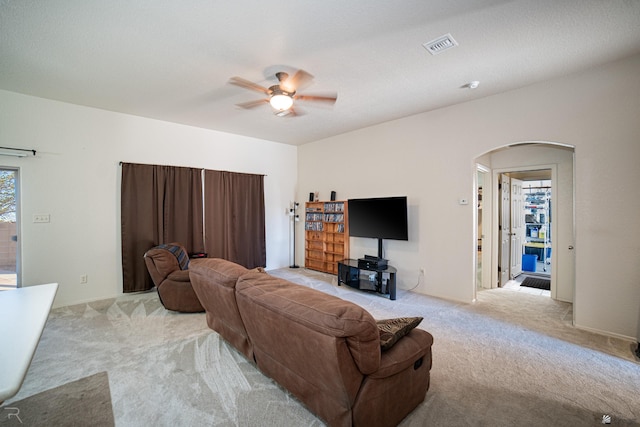 carpeted living room with ceiling fan