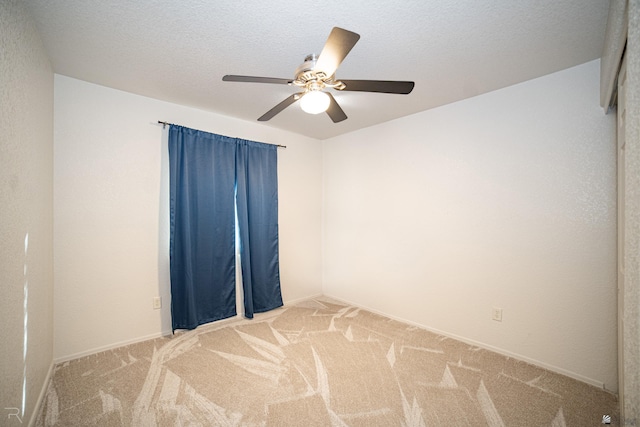 carpeted empty room featuring ceiling fan and a textured ceiling