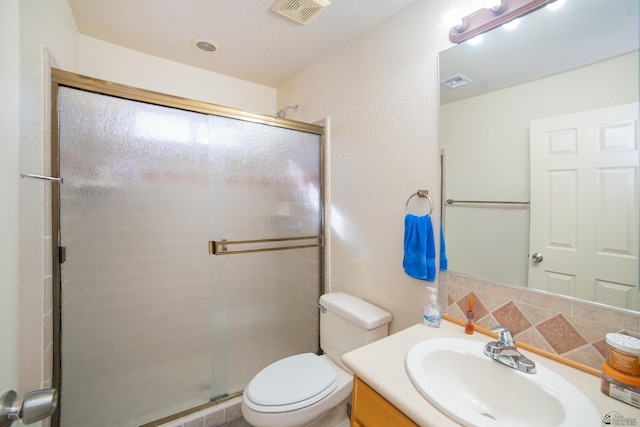 bathroom featuring vanity, toilet, and a shower with door