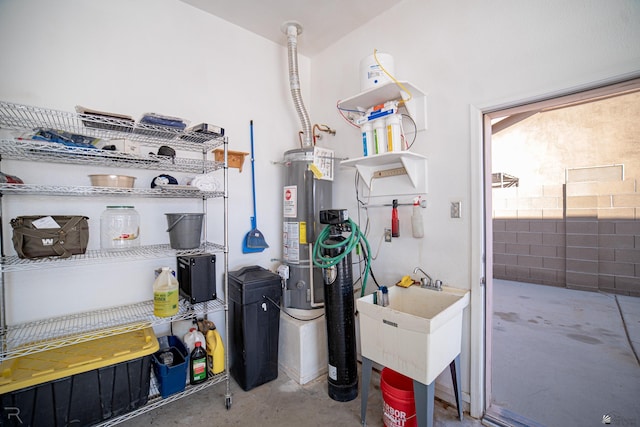 utility room featuring gas water heater and sink