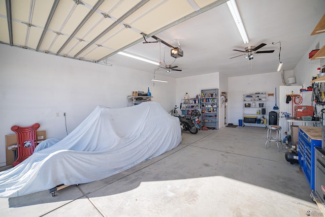 garage featuring a garage door opener, ceiling fan, and a workshop area