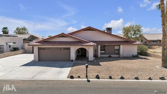 view of front facade featuring driveway, a tiled roof, an attached garage, and stucco siding