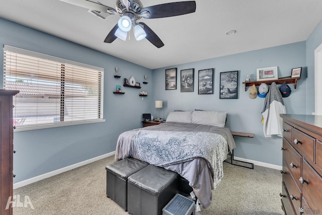 bedroom with light colored carpet, ceiling fan, visible vents, and baseboards