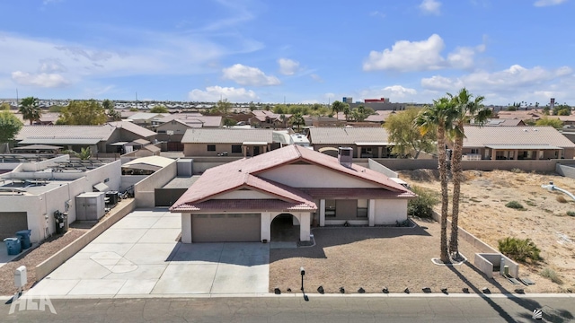 view of front of home featuring a garage, fence, driveway, a residential view, and stucco siding