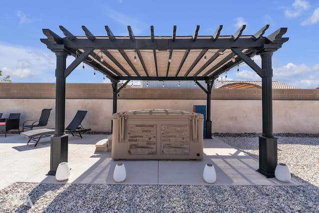 view of patio with a hot tub, a pergola, and a fenced backyard