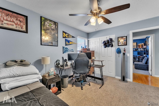 bedroom featuring a ceiling fan, a closet, carpet flooring, and a textured ceiling