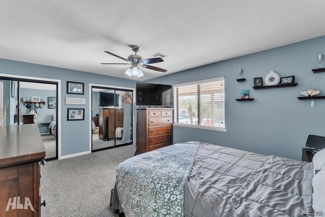 bedroom featuring ceiling fan, a textured ceiling, visible vents, baseboards, and carpet