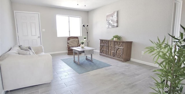 living area featuring baseboards and wood finished floors