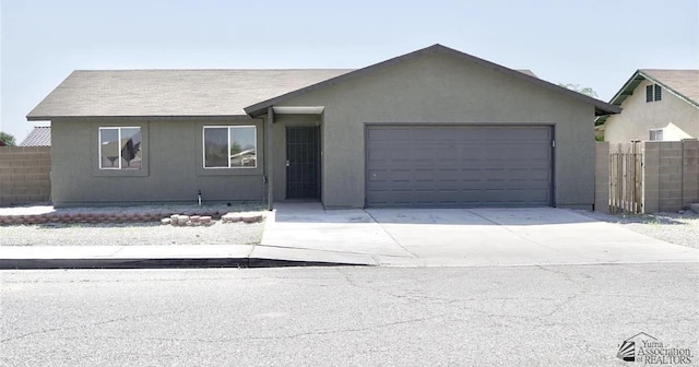 ranch-style home featuring concrete driveway, a garage, fence, and stucco siding