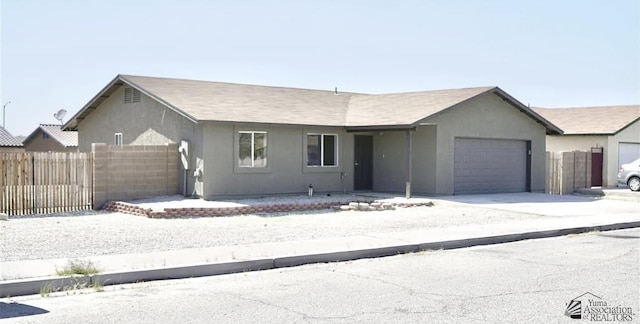 single story home featuring an attached garage, fence, stucco siding, and driveway