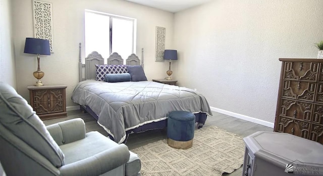 bedroom featuring baseboards and wood finished floors