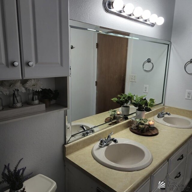 1957 Athens Ave, Yuma, AZ 85364 - bathroom with double vanity, a sink, and toilet