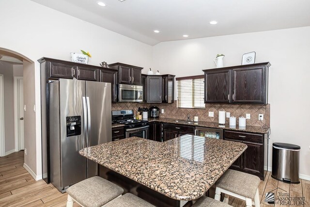 10120 S Galaxy Ave, Yuma, AZ 85367 - kitchen featuring stainless steel appliances, arched walkways, a sink, and a kitchen bar