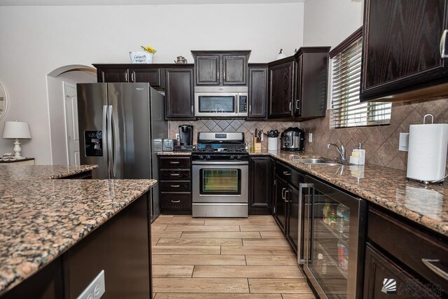 10120 S Galaxy Ave, Yuma, AZ 85367 - kitchen with appliances with stainless steel finishes, a sink, wood tiled floor, backsplash, and wine cooler