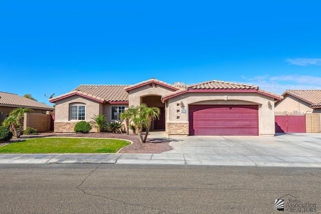 10120 S Galaxy Ave, Yuma, AZ 85367 - mediterranean / spanish-style house featuring a tiled roof, driveway, fence, an attached garage, and stucco siding
