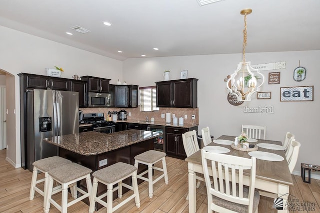 10120 S Galaxy Ave, Yuma, AZ 85367 - kitchen with a breakfast bar area, visible vents, light wood-type flooring, an inviting chandelier, and stainless steel appliances