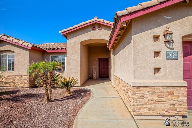 10120 S Galaxy Ave, Yuma, AZ 85367 - view of exterior entry featuring a tiled roof, stone siding, and stucco siding