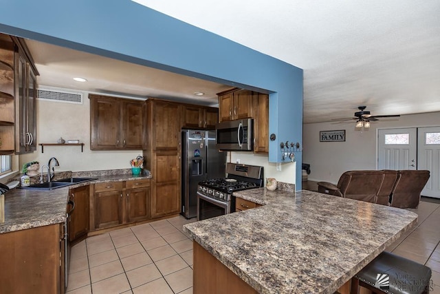 285 E 26th St, Yuma, AZ 85364 - kitchen with stainless steel appliances, open shelves, a peninsula, light tile patterned flooring, and ceiling fan
