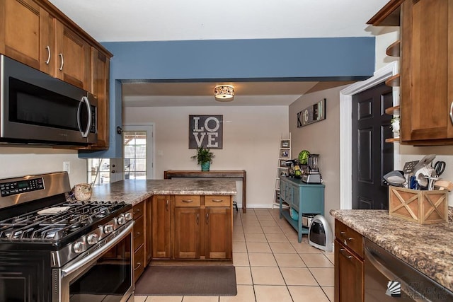 285 E 26th St, Yuma, AZ 85364 - kitchen featuring appliances with stainless steel finishes, a peninsula, brown cabinetry, and light tile patterned floors