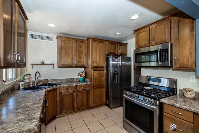 285 E 26th St, Yuma, AZ 85364 - kitchen with stainless steel appliances, dark countertops, recessed lighting, brown cabinetry, and light tile patterned flooring