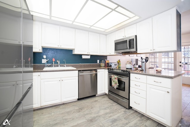 2231 S Elks Ln # 67, Yuma, AZ 85364 - kitchen featuring stainless steel appliances, a sink, dark countertops, and white cabinetry