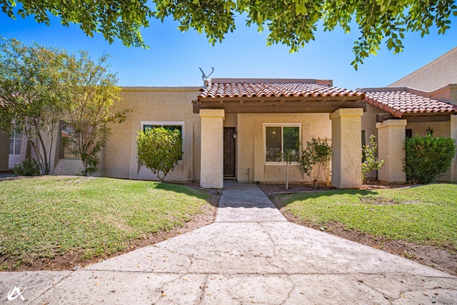 2231 S Elks Ln # 67, Yuma, AZ 85364 - mediterranean / spanish house featuring a tile roof, a front yard, and stucco siding