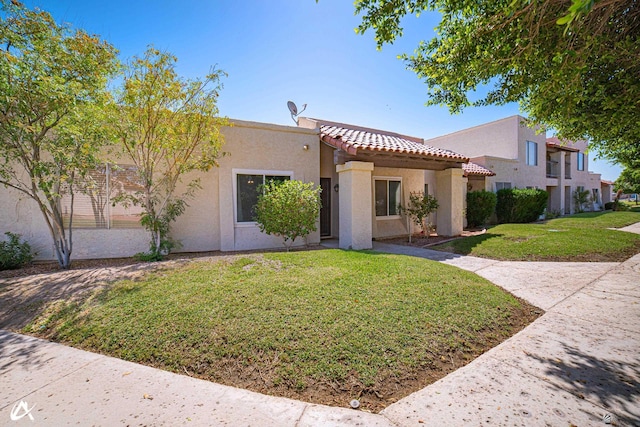 2231 S Elks Ln # 67, Yuma, AZ 85364 - mediterranean / spanish-style home with a tiled roof, stucco siding, and a front lawn