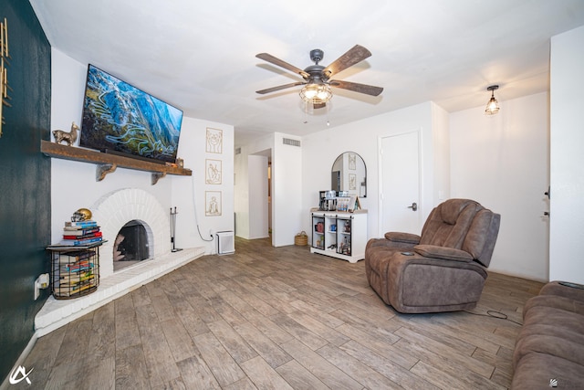 2231 S Elks Ln # 67, Yuma, AZ 85364 - living area with ceiling fan, wood finished floors, and a brick fireplace