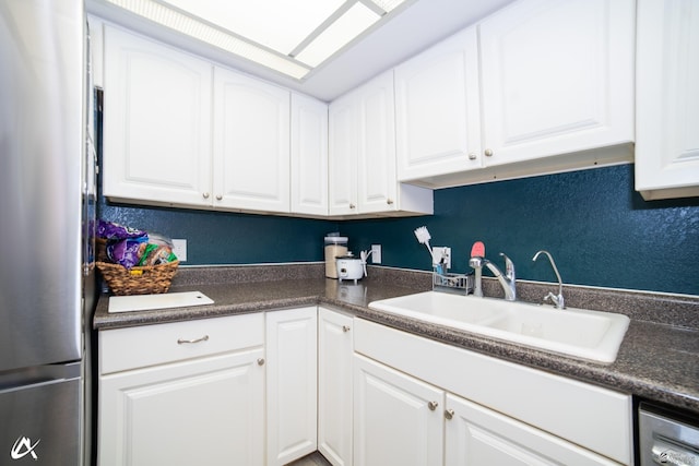 2231 S Elks Ln # 67, Yuma, AZ 85364 - kitchen featuring freestanding refrigerator, a sink, dark countertops, and white cabinets