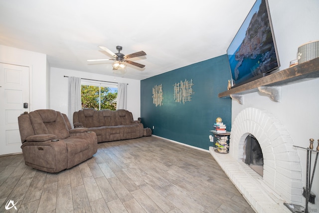 2231 S Elks Ln # 67, Yuma, AZ 85364 - living room with ceiling fan, wood finished floors, a brick fireplace, and baseboards