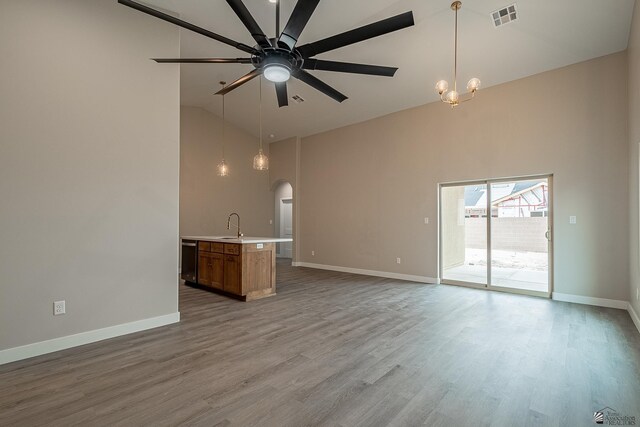 7972 E 34th Ln, Yuma, AZ 85365 - unfurnished living room with baseboards, arched walkways, high vaulted ceiling, and ceiling fan