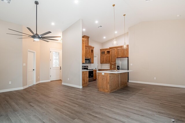 7972 E 34th Ln, Yuma, AZ 85365 - kitchen with stainless steel appliances, open floor plan, and brown cabinetry