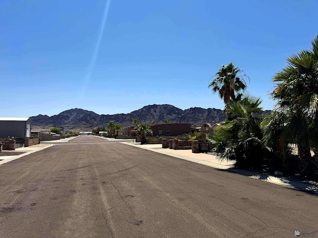 14713 E 52nd Dr, Yuma, AZ 85367 - view of asphalt road featuring sidewalks, a mountain view, and curbs