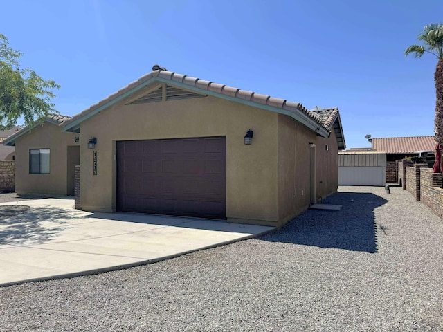 14713 E 52nd Dr, Yuma, AZ 85367 - view of home's exterior featuring concrete driveway, an attached garage, stucco siding, and a tiled roof
