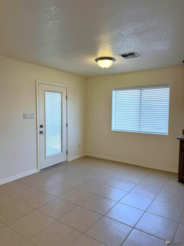 14713 E 52nd Dr, Yuma, AZ 85367 - spare room with a textured ceiling, baseboards, and light tile patterned floors