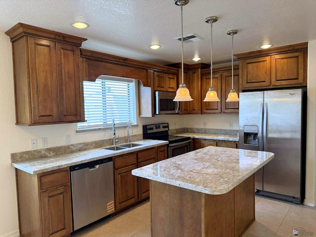 14713 E 52nd Dr, Yuma, AZ 85367 - kitchen with appliances with stainless steel finishes, a sink, light tile patterned floors, a center island, and brown cabinets