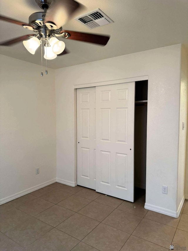 14713 E 52nd Dr, Yuma, AZ 85367 - unfurnished bedroom featuring light tile patterned floors, a closet, baseboards, and a ceiling fan